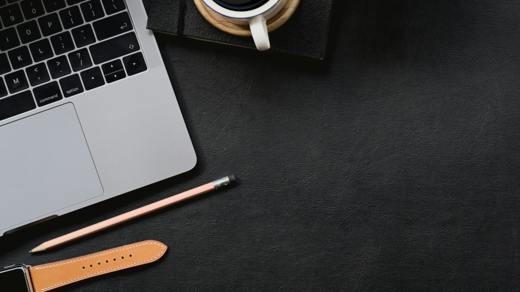 Image of a desk with laptop, watch, pencil, coffee mug, and Desk mat